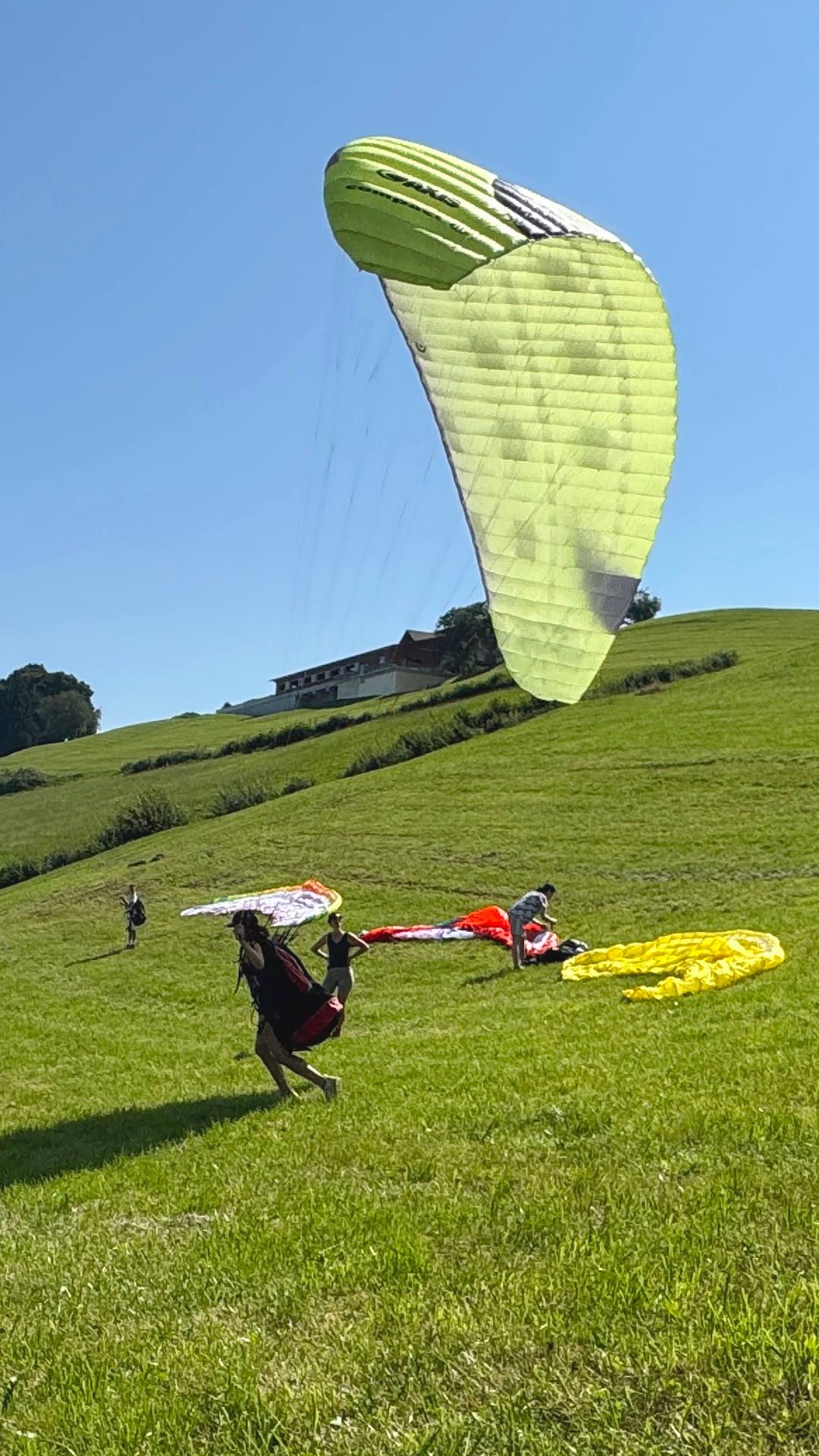 gleitschirm-flugschueler-laufuebungen-hoch Eine Teilnehmerin im Gleitschirm-Grundkurs zieht den Schulschirm gekonnt auf und gibt dabei acht, genau mittig unter dem Segel positioniert zu bleiben.