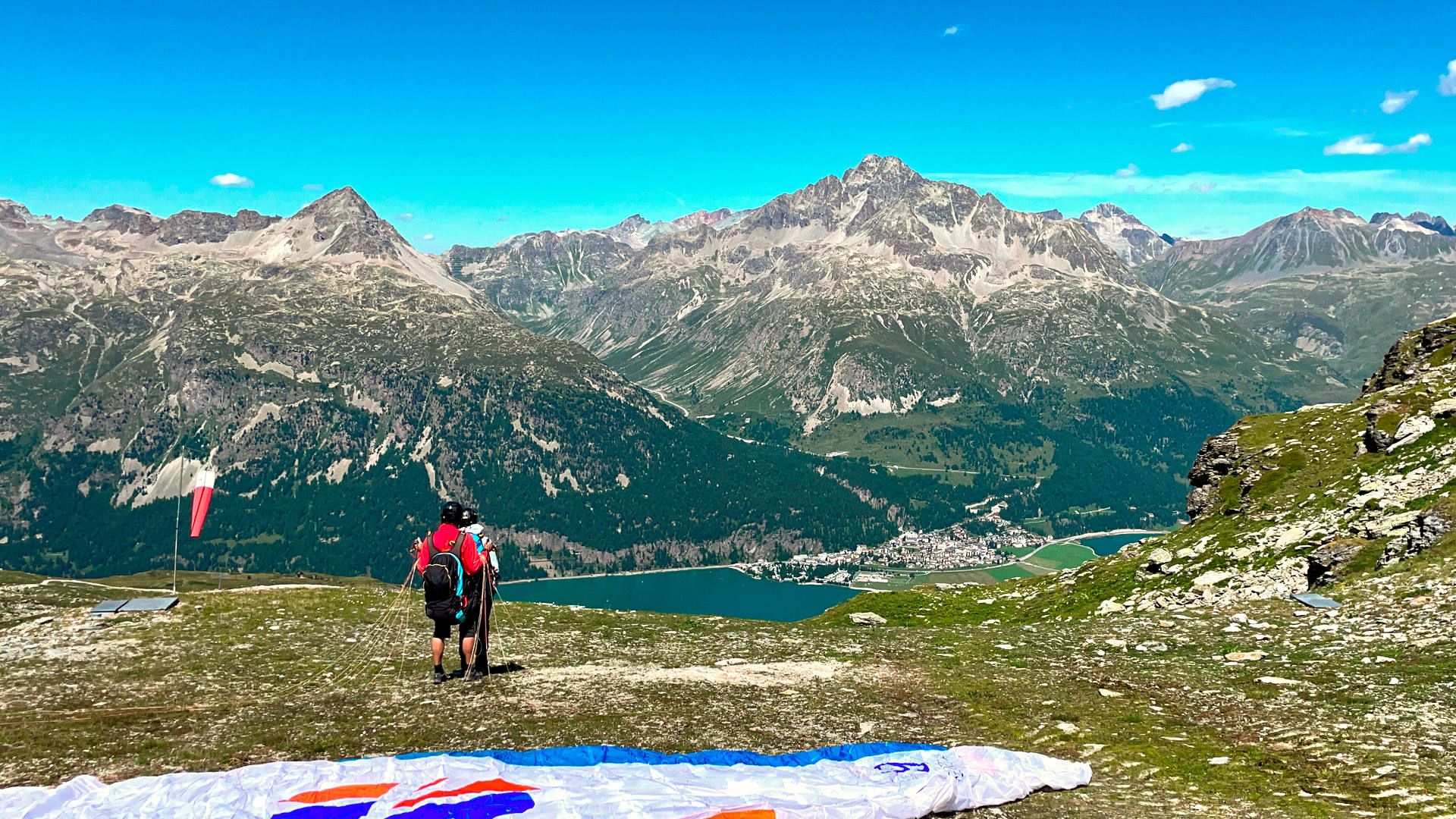 Pilot und Passagier sind Startklar für einen Gleitschirn-Tandemflug von Murtèl am Corvatsch nach Silvaplana im Hochsommer.