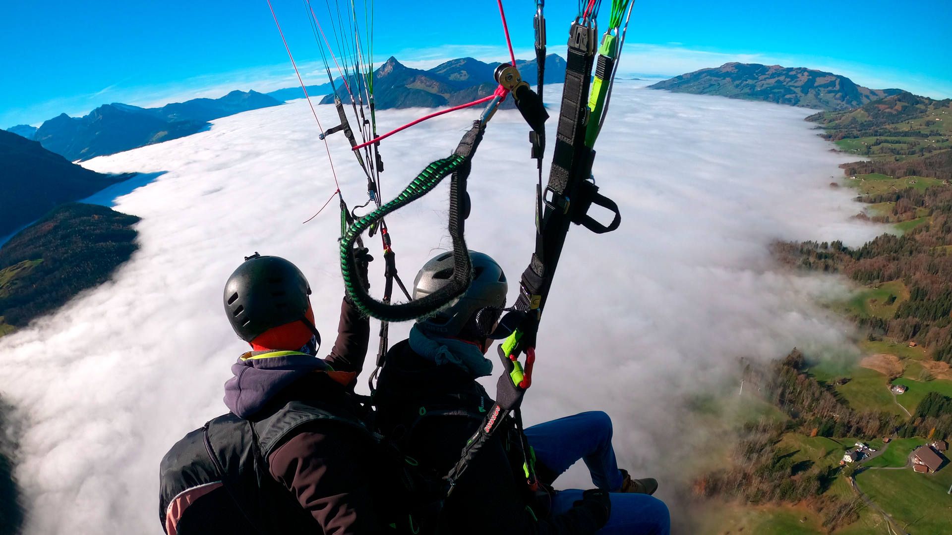 Flugaufnahme: Bei einem herbstlichen Tandemflug über Sattel Schwyz in klarer Luft sieht man unten ein ausgedehntes Nebelmeer.