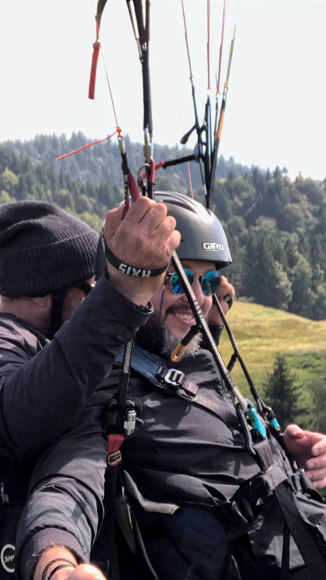 Flugaufnahme: Während der Tandempassagier die Aussicht bei einem Gleitschirmflug geniesst, steuert der Pilot gezielt die nächste Aufwindquelle an.