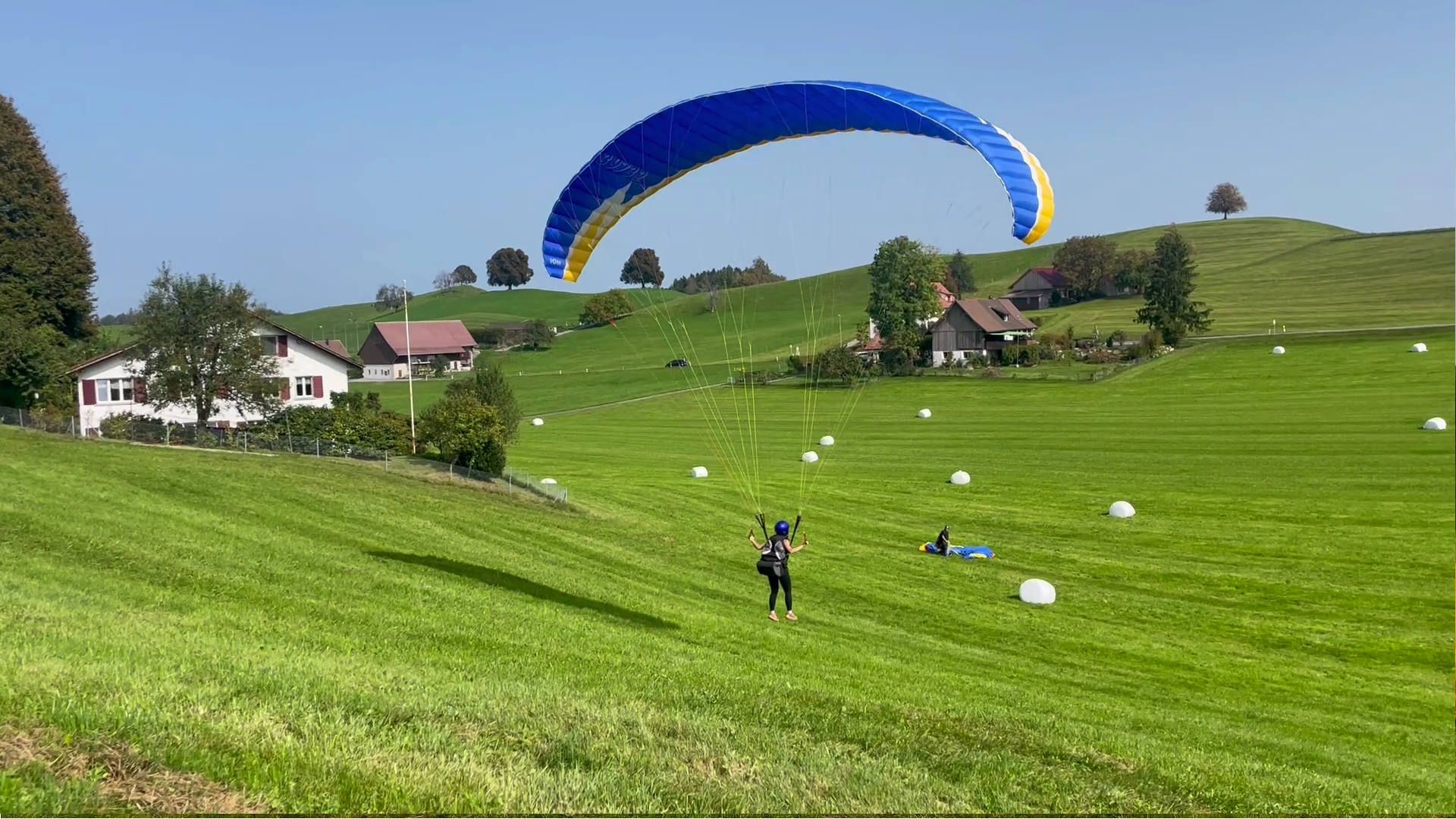 Eine Teilnehmerin beim Gleitschirm-Schnuppertag ist mit ein paar beherzten Schritten am Übungshang abgehoben.