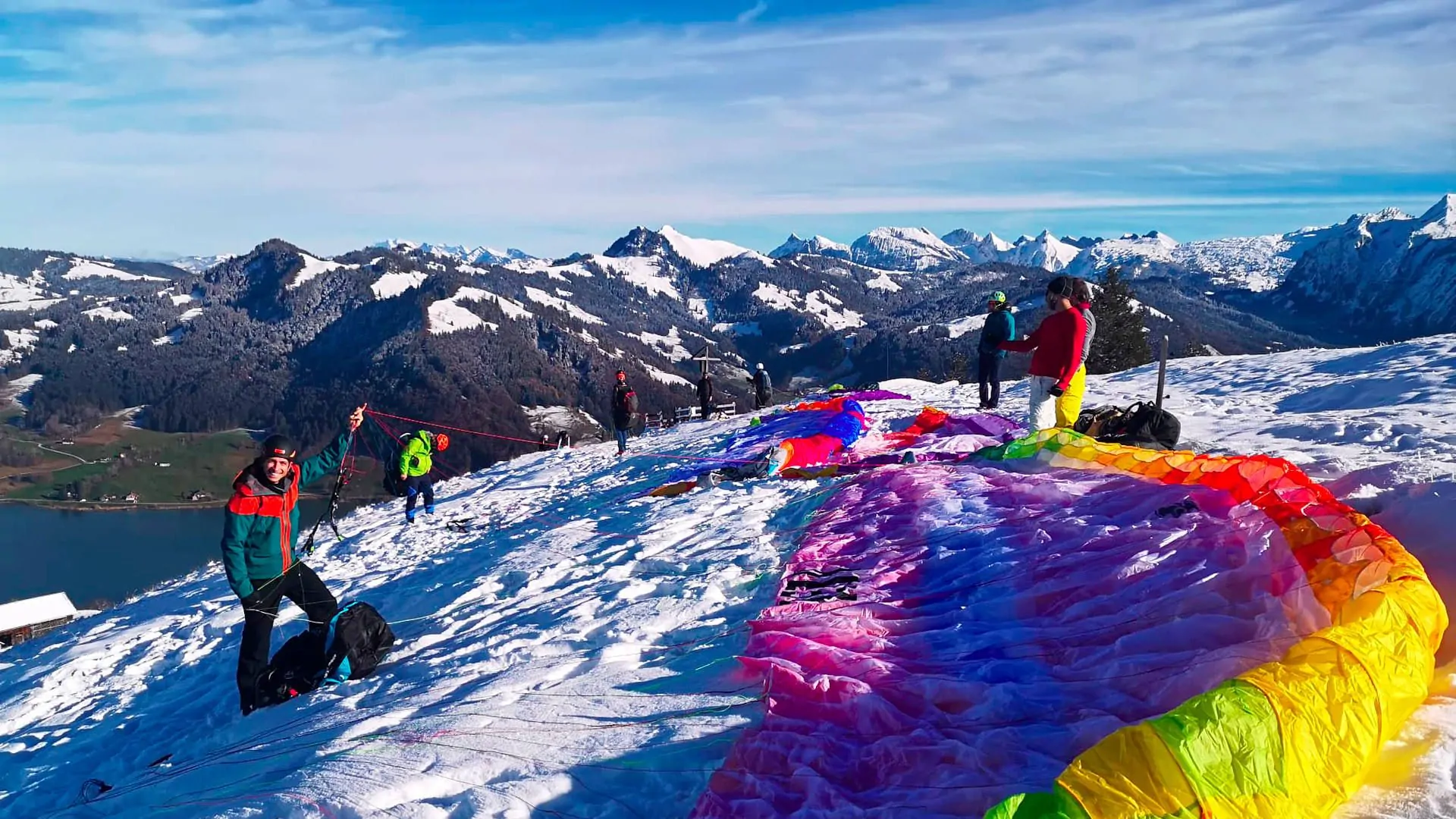 gleitschirmfliegen-fruehling-startplatz-hummel-einsiedeln-startvorbereitung-flugschlueler-quer Flugschüler bei den Flugvorbereitungen an einem spätwinterlichen Flugtag im Fluggebiet Hummel bei Einsiedeln.