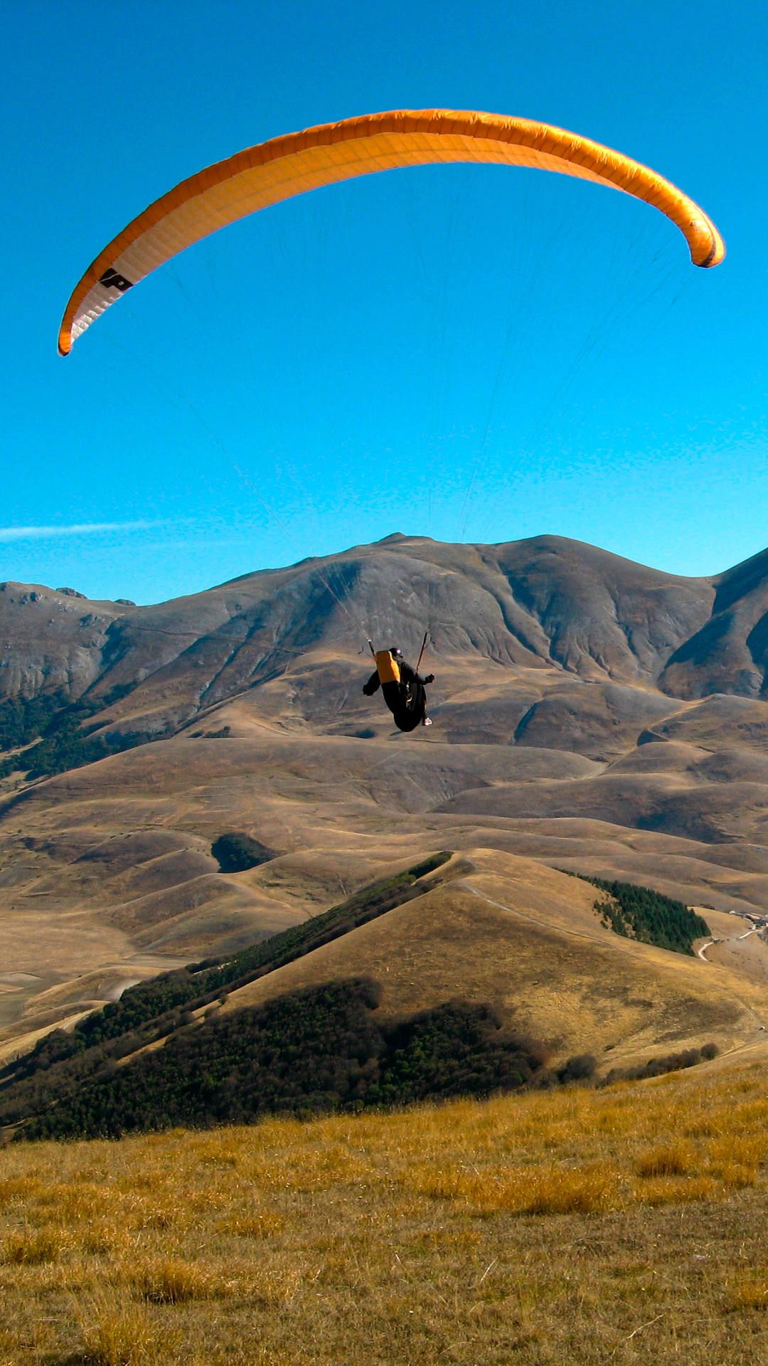 Ein Pilot setzt mit seinem Gleitschirm am Monte Veletta aus passender Höhe zu einer Landung an.