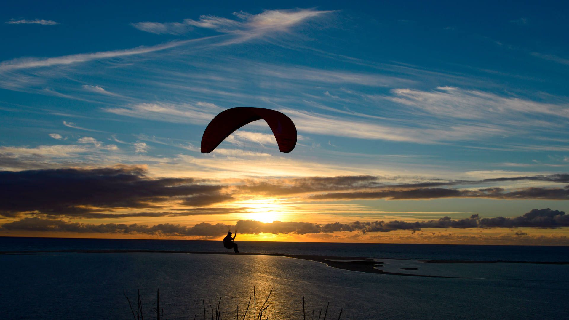 Ein Gleitschirmpilot kostet den laminaren Aufwind an der Dune du Pyla bis Sonnenuntergang aus.