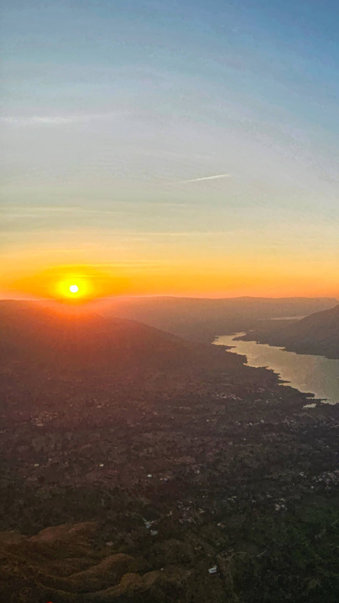 Flugaufnahme: Abendstimmung aus der Pilotenperspektive beim Sonnenuntergang während eines Abendflugs auf Panchganis Westseite.