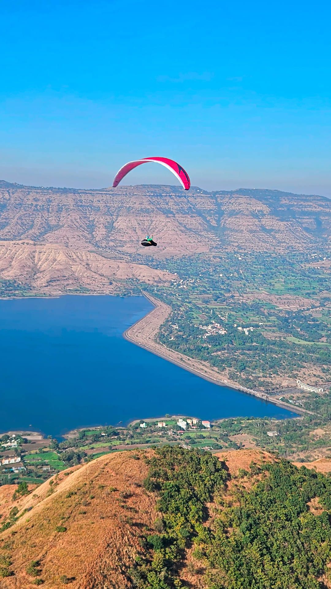 Ein Gleitschirm dreht im thermischen Aufwind bei einem Streckenflug von Panchgani vor der Talquerung in Richtung Madar Devi.