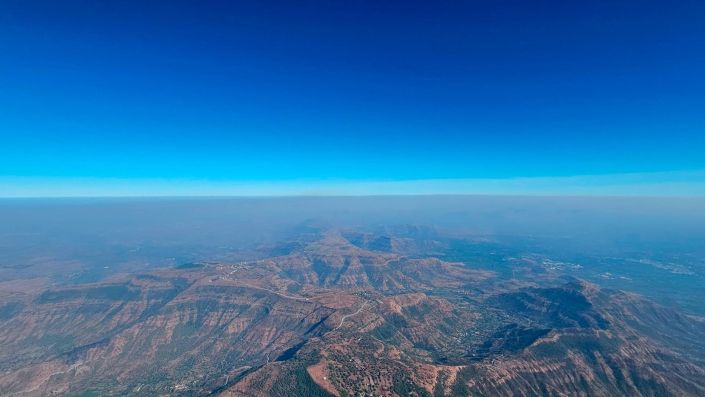 Flugaufnahme: Auf Streckenflug mit dem Gleitschirm entlang der Mandar-Devi-Ridge Richtung Osten mit Blick zurück zur Tempelanlage in Madar Devi.
