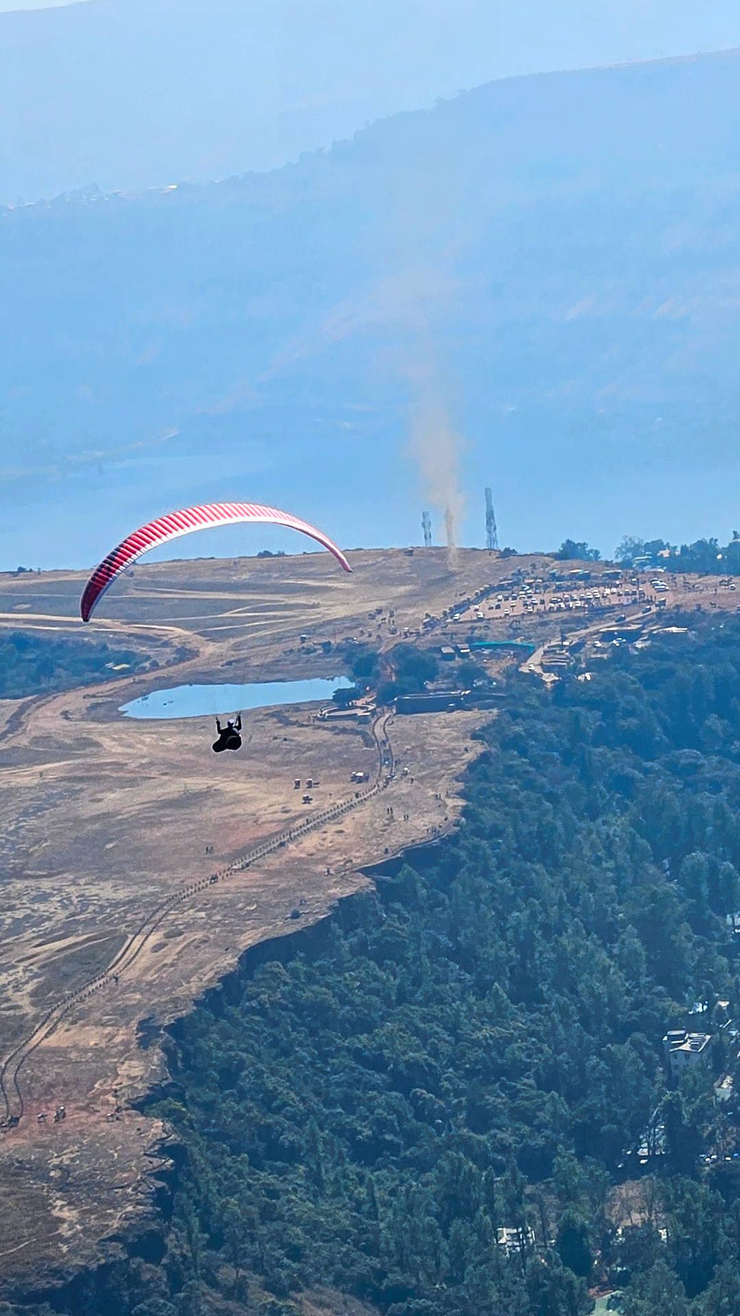 Flugaufnahme: Ein Gleitschirm über dem Tableland von panchgani, wo sich ein grosser Dust Devil gebildet hat.
