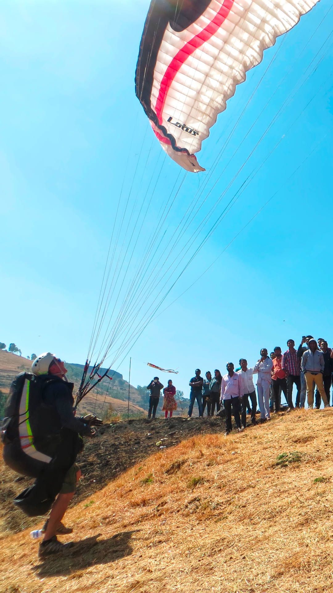 Rückwärtsstart zu einem Gleitschirmflug vom Startplatz Harrisson Folly bei Panchgani vor vielen indischen Zuschauern.