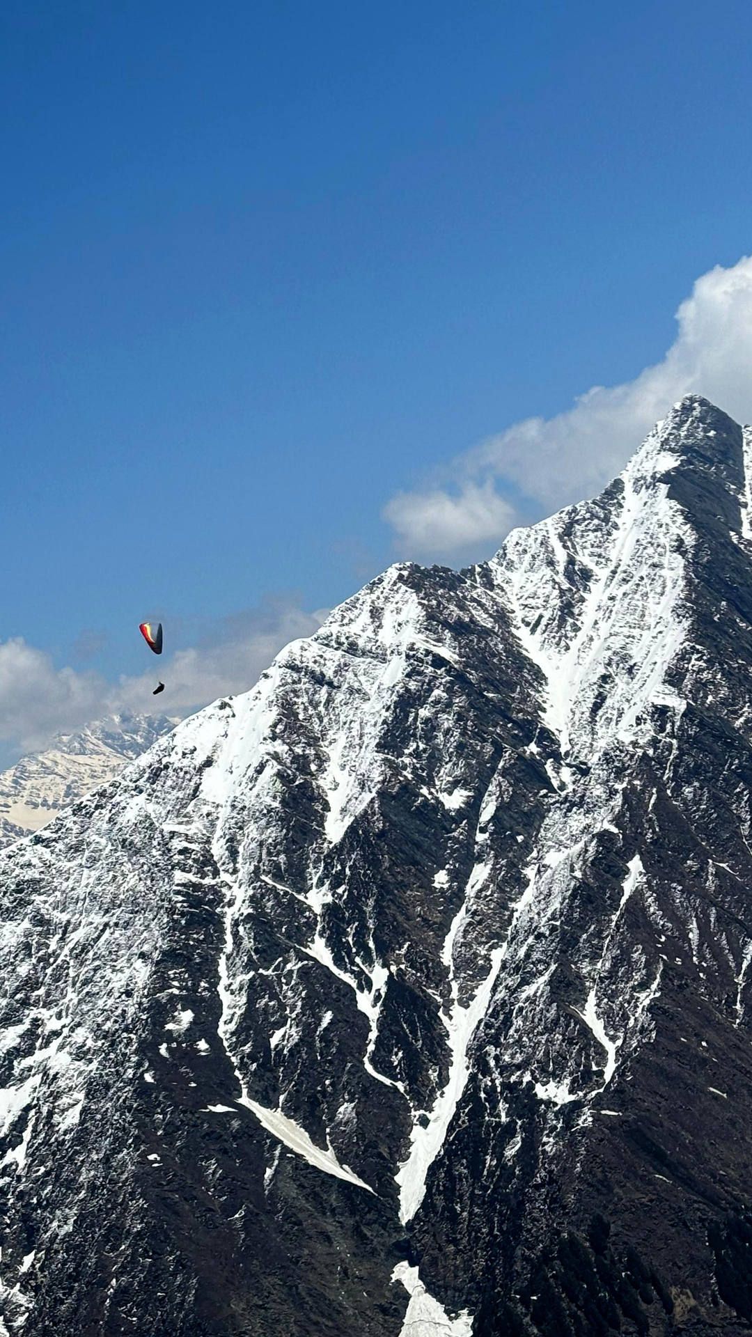 Flugaufnahme: Bei einem Streckenflug von Bir-Billing in die Back-Mountains der Dhauladhar-Range nimmt ein Gleitschirmpilot Kurs auf die Eiswüsten.